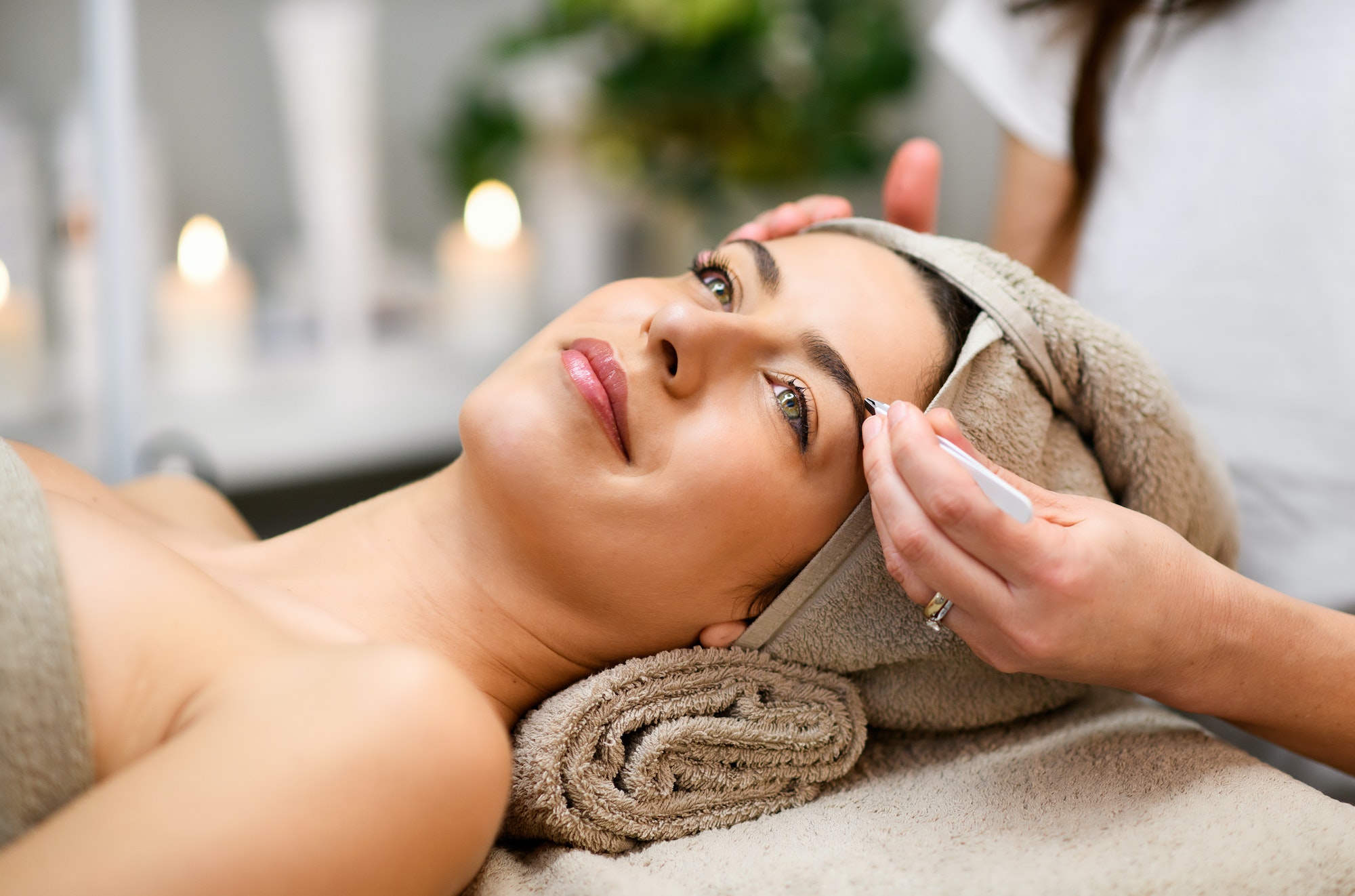 Woman having eyebrows treatment in spa salon